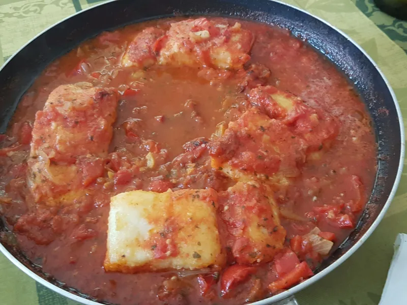 Bacalao con tomate al punto, jugoso y con salsa para mojar pan